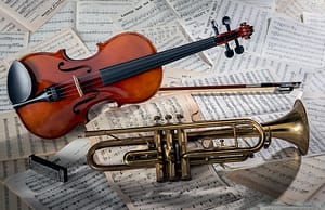 Closeup of a violin and a trumpet on note sheets under the lights - perfect for musical concepts