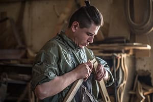 male carpenter working with a wood product, hand tools